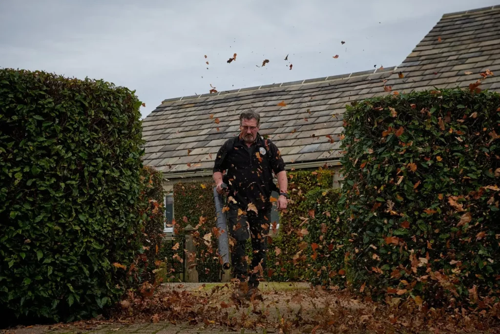 Gardener blowing leaves