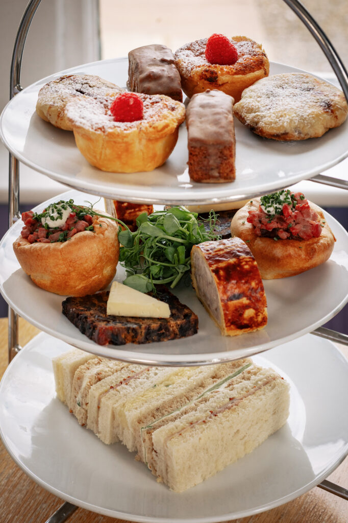 An afternoon tea stand at The Fell Hotel filled with sandwiches, sweets and scones.