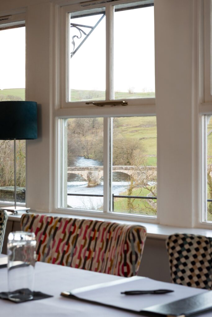 A view out of the conservatory window of the river and bridge, with the corporate table in the foreground.