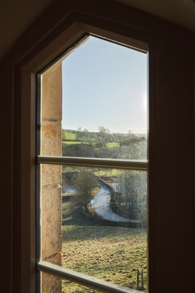 The view out of a window with a winding bridge and the river running through.