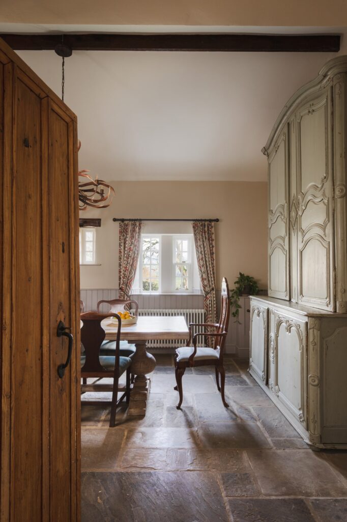 Rustic farmhouse dining room with old dresser and chairs.