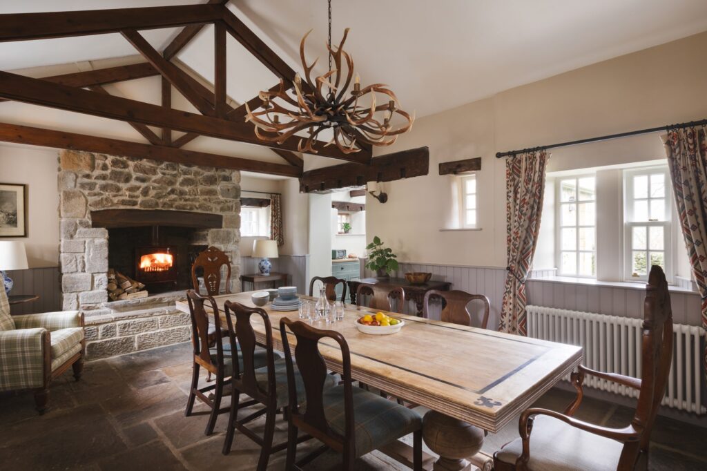 Rustic dining room with large open fire and rustic and antique furniture.