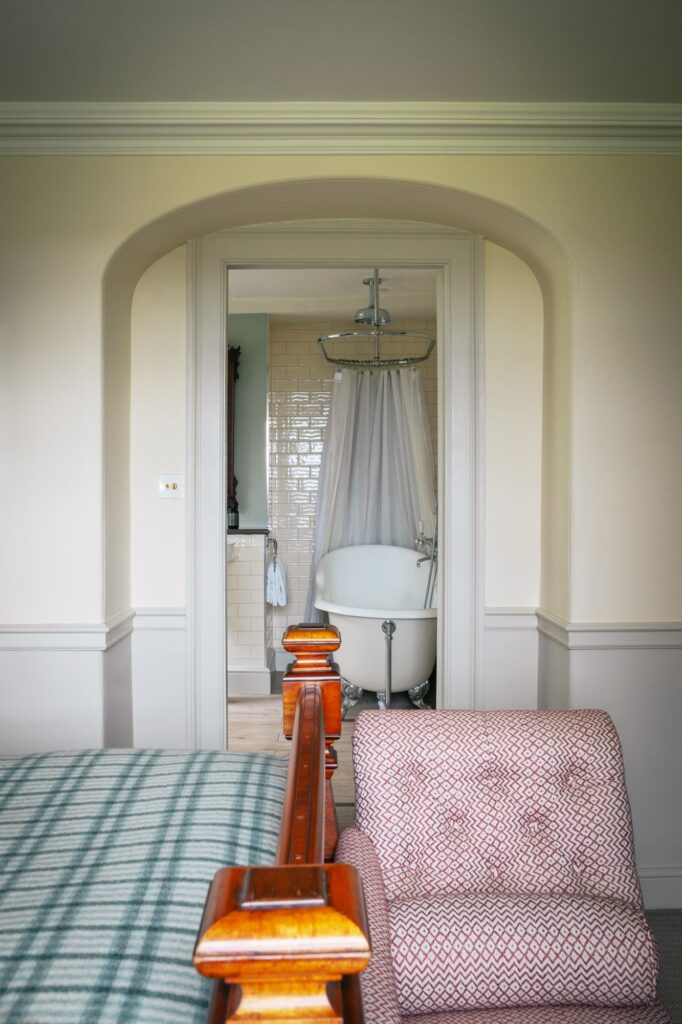 View from bedroom into bathroom with roll top bath.