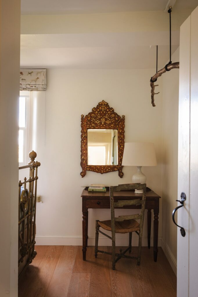 Inside the bedroom from the doorway, a desk and antique furnishings.