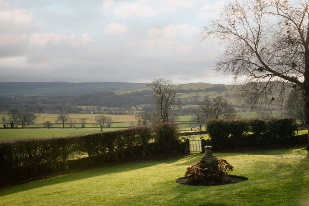 View from the garden, with morning sunlight and frost on the lawn and the valley beyond.