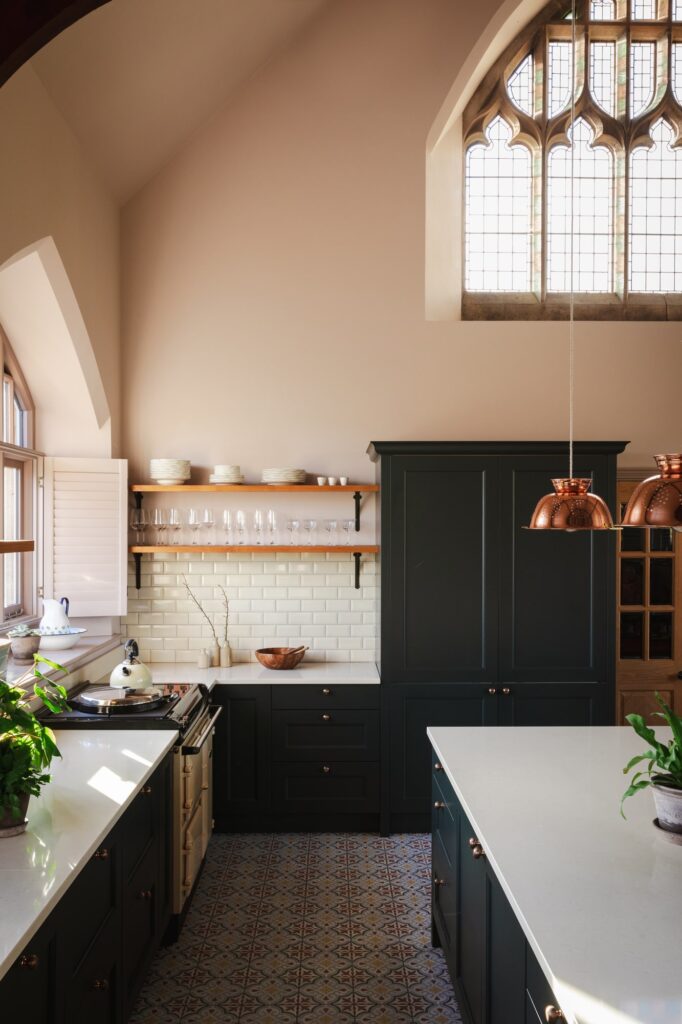 Rustic furnishings in the kitchen with the original large stained glassed window from the chapel.