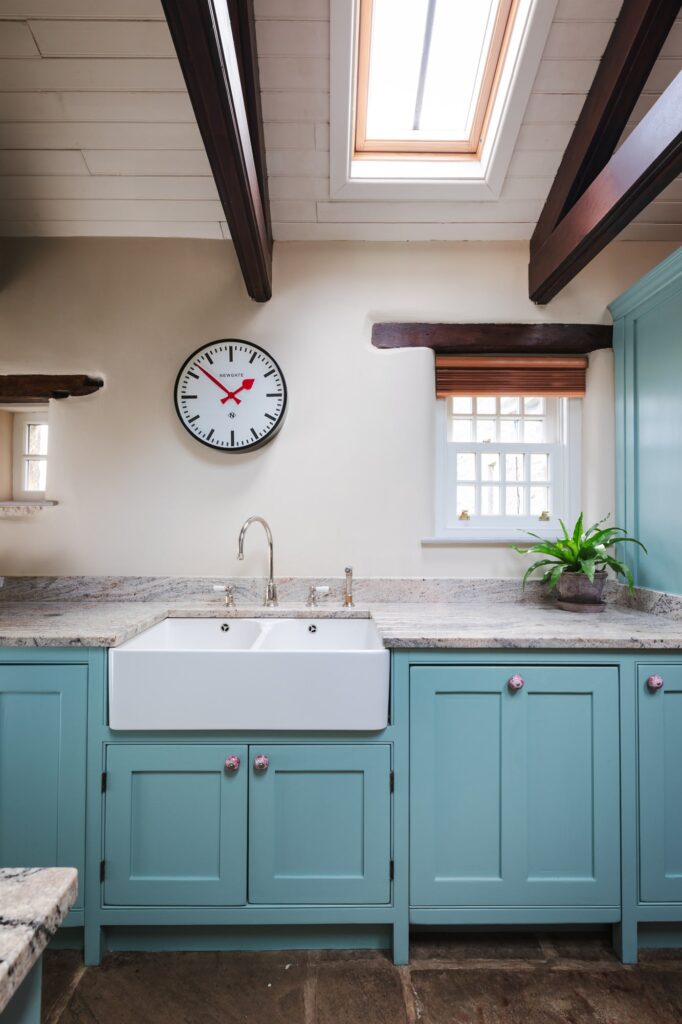 Farmhouse kitchen with marble counter tops and blue doors.