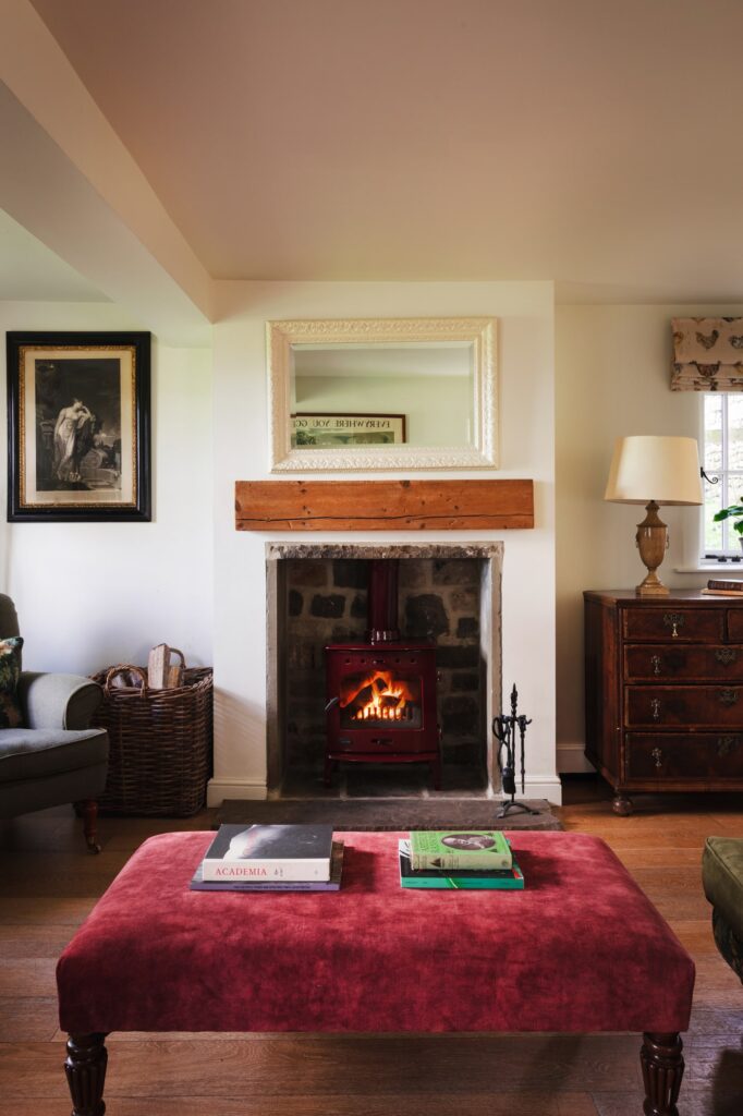 Rustic farmyard living room with roaring open fire and antique furniture.