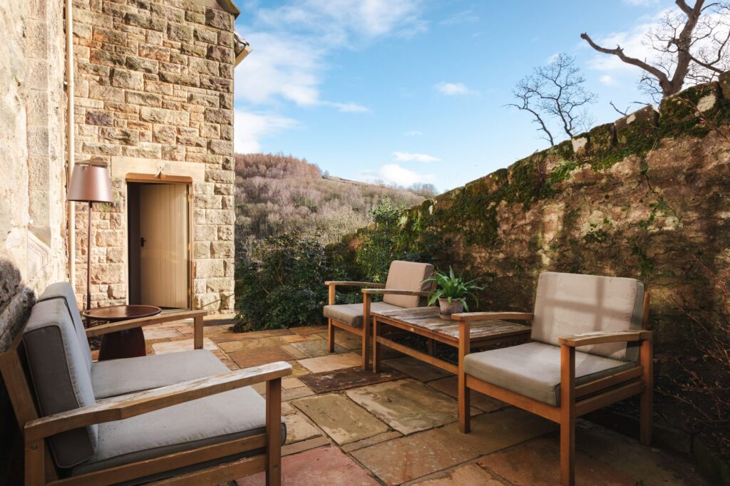 Outside patio with comfy garden furniture in the sunlight.