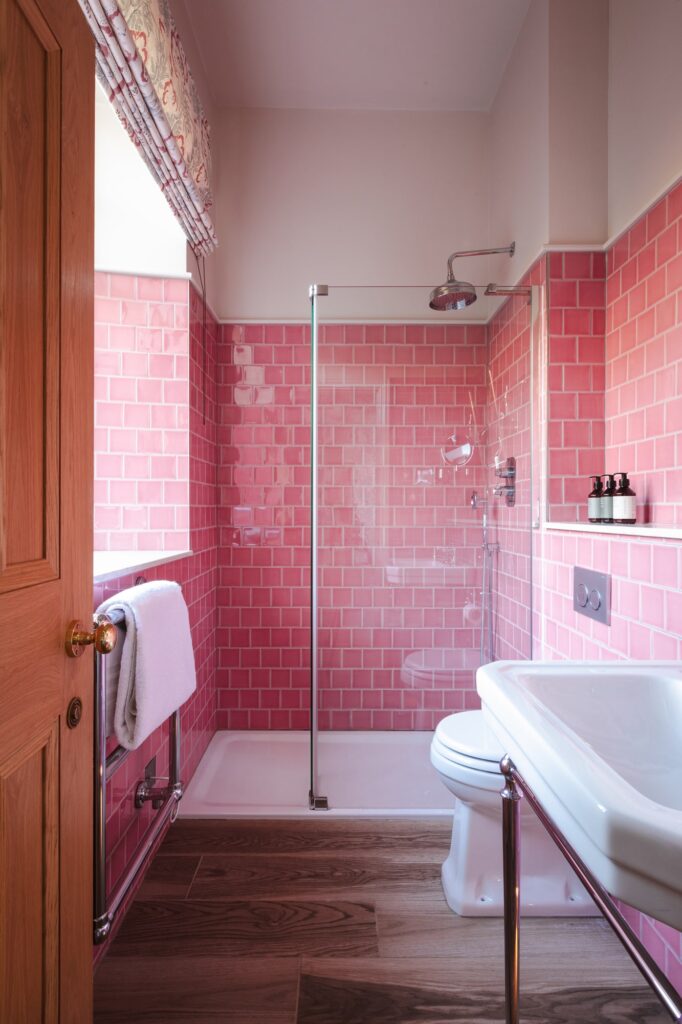 A pink-tiled bathroom with walk-in shower.