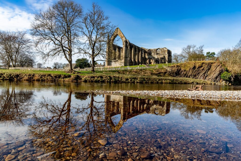 The abbey during the summertime, with the River Wharfe flowing in-front.