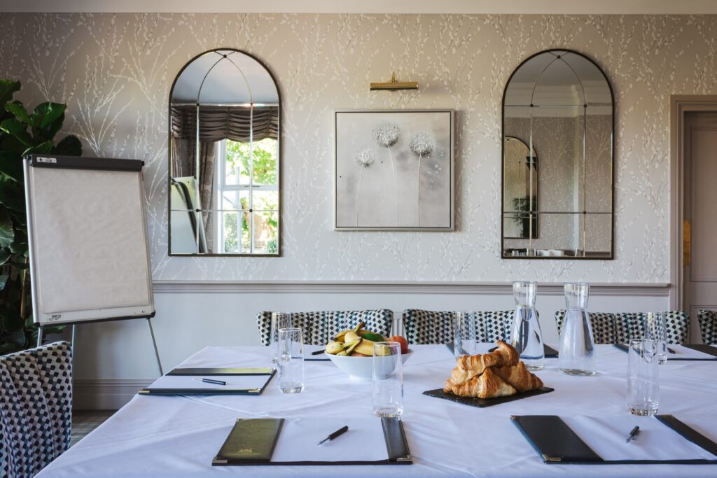 A corporate table set up with fresh fruit, pads and pens and a flip chart in the corner.