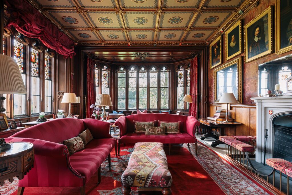 A large open living area furnished with antiques and treasures, the room is mainly red.