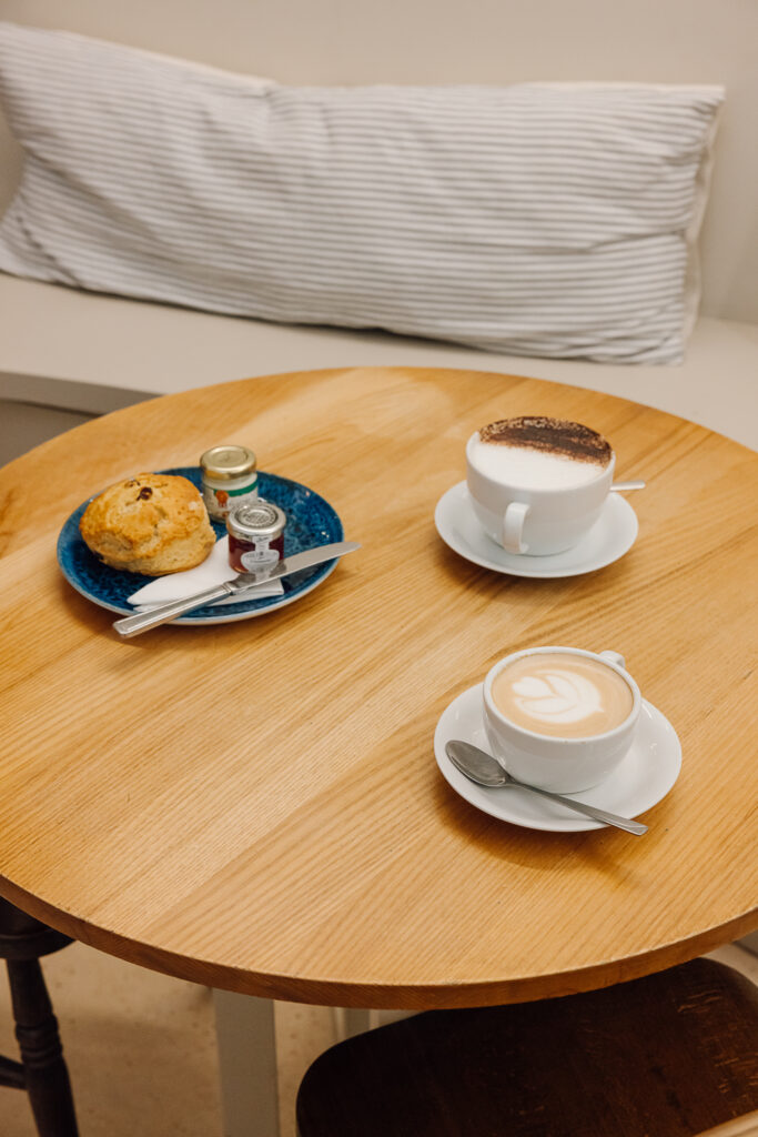 A Latte, Cappuccino and Scone laid on a table at Strid Wood Tea Rooms