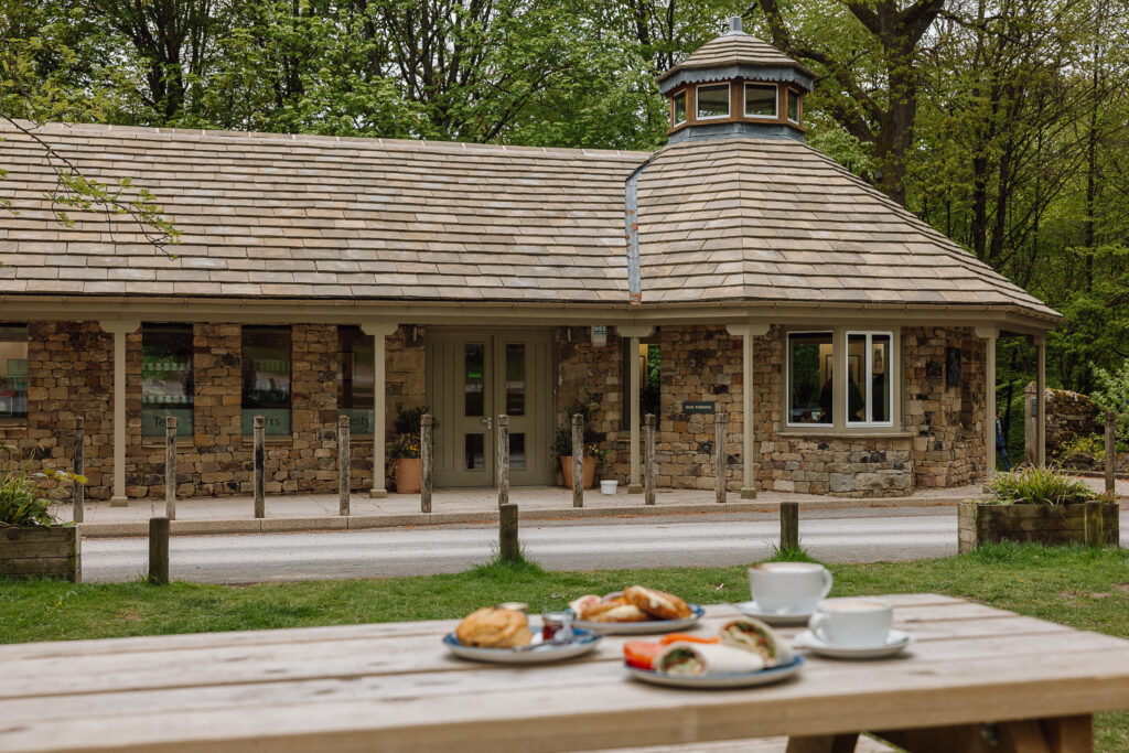 The outside of Strid Wood Tea Rooms with a picnic bench and lunch items laid upon it.